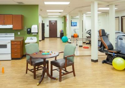 Rehab gym with kitchennette, colorful balls, stationary bikes and other equipment