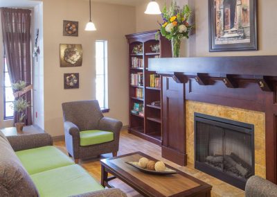 Recreation room with fireplace, bookshelf, sofa and chairs